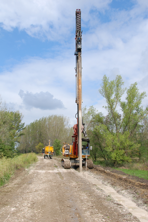 eine Baumaschine an der March bereitet das Erdreich für vertikale Betonwände vor