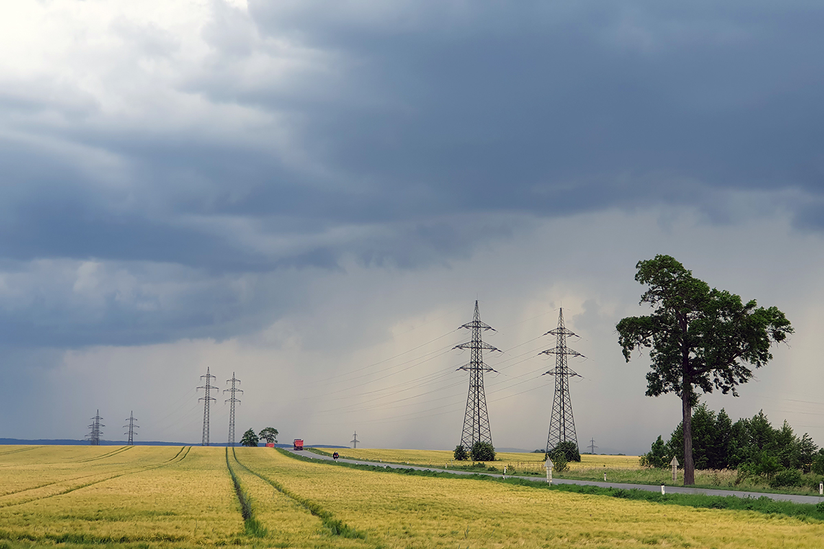 Strommasten mit Leitung über eine Straße